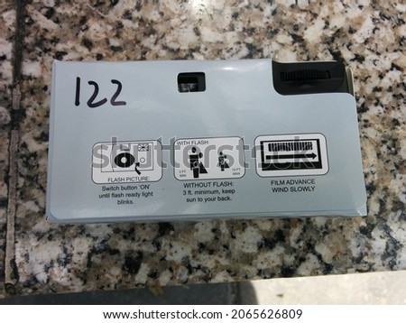Single use camera with the number 122 handwritten on it