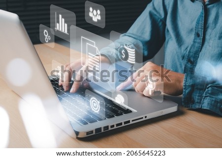 Enterprise Resource Planning ERP, document management concept with icons on virtual screen, Business woman working with laptop computer with icons on virtual screen on office desk. Royalty-Free Stock Photo #2065645223