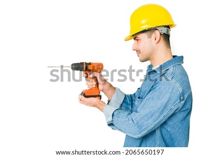 Professional contractor drilling on a wall against a white background. Handyman doing some renovations 