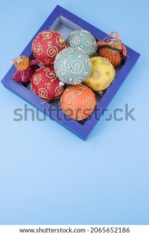 Multicolored Christmas decorative balls and figurines in a blue wooden box with sapce for text