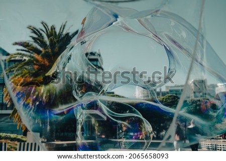 A closeup shot of a city through floating soap bubbles