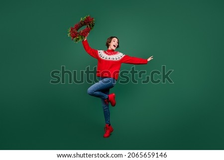 Full length body size view of attractive cheerful girl holding festal wreath dancing rest isolated over green color background