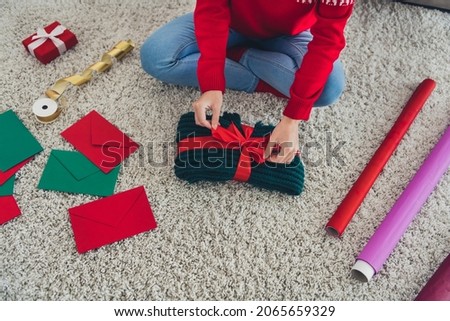 Cropped photo of lady hands prepare knitwear gift pack red bow wear hat sweater in decorated x-mas home indoors