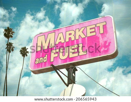 aged and worn vintage photo of market and fuel sign with palm trees                               