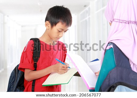 Portrait of boy and girl studying in school