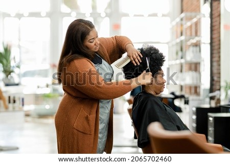 Hairstylist trimming the customer 39;s hair at a beauty salon Royalty-Free Stock Photo #2065702460