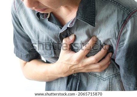 Man is sick and in pain and uses his hands to squeeze his chest He had chest pain caused by an acute heart attack. medical and health concepts Royalty-Free Stock Photo #2065715870