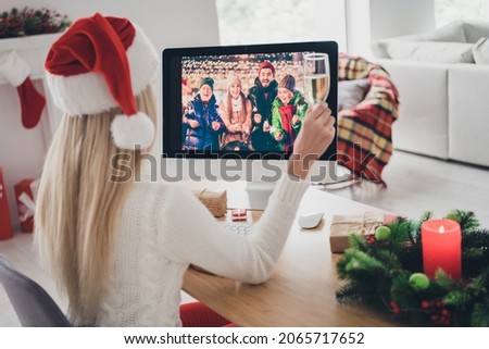 Back rear spine view photo of young woman wear santa claus hat sit desk hold champagne talk indoors inside house home Royalty-Free Stock Photo #2065717652