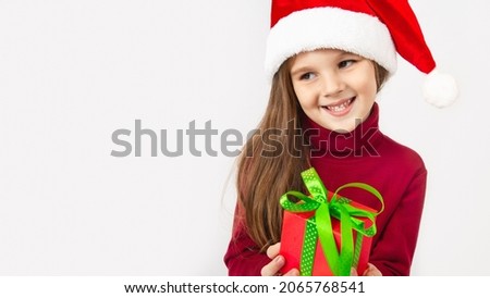 Cheerful little girl 5 years old isolated on white background holding a present box. copy space