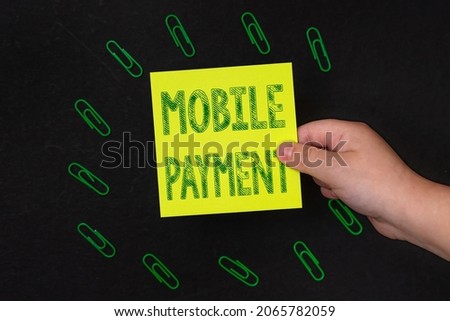 Conceptual caption Mobile Payment. Business overview Cashless Payment made through portable electronic devices Multiple assorted collection office stationery photo placed over table