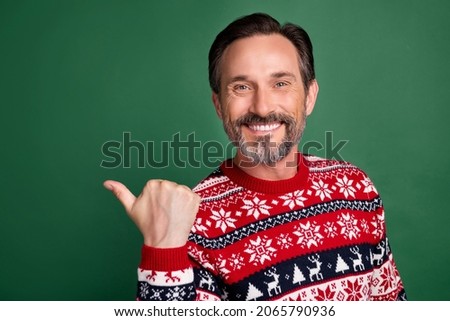 Photo of positive cheerful happy mature man point finger thumb empty space isolated on green color background