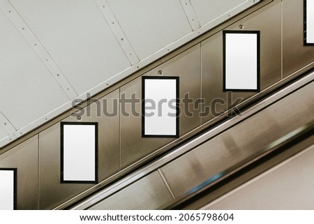 Billboard screens by underground escalator Royalty-Free Stock Photo #2065798604