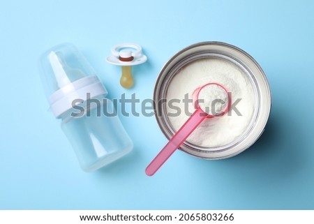 Flat lay composition with powdered infant formula on light blue background. Baby milk Royalty-Free Stock Photo #2065803266