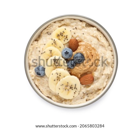 Tasty oatmeal porridge with different toppings in bowl on white background, top view Royalty-Free Stock Photo #2065803284