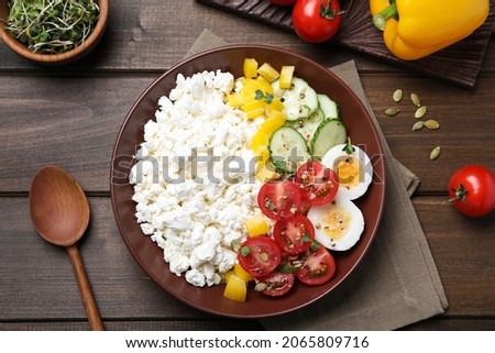 Delicious cottage cheese with vegetables and boiled egg served for breakfast on wooden table, flat lay Royalty-Free Stock Photo #2065809716