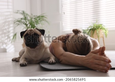 Woman with dog practicing yoga at home