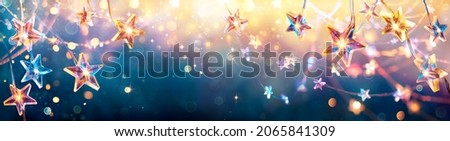 Christmas Stars Golden Lights Hanging In Blue Background - String With Abstract Defocused Element