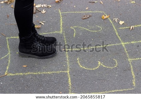 girl playing hopscotch game on the street
