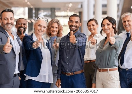 Group of happy multiethnic business people showing sign of success. Successful business team showing thumbs up and looking at camera. Portrait of smiling businessmen and businesswomen cheering. Royalty-Free Stock Photo #2065857017