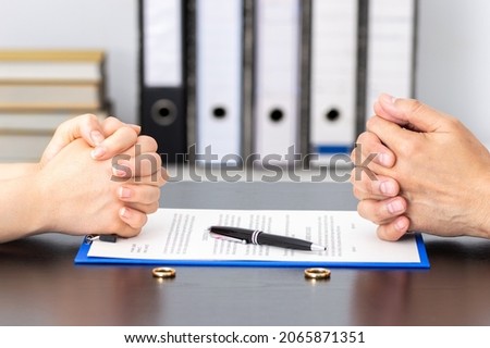 Hands of wife and husband signing divorce documents or premarital agreement at the lawyer's office Royalty-Free Stock Photo #2065871351