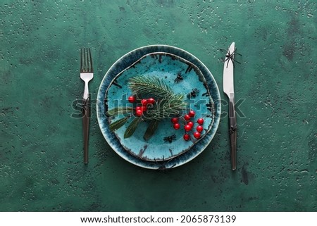Halloween table setting with spiders and rowan on green background