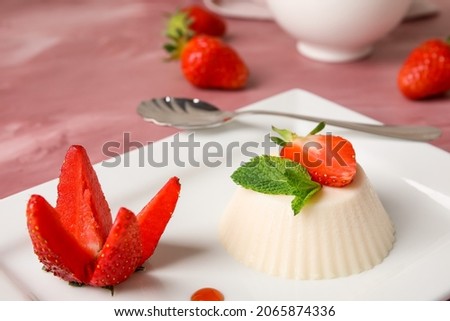 Plate with tasty strawberry panna cotta on table, closeup