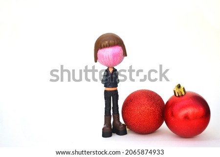 Christmas ball set. Doll with ball head and red Christmas balls on a white background. Fun and creative composition with copy space. Christmas card concept.