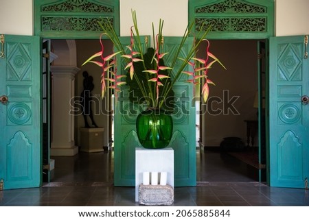 Entrance to a luxury villa to have spiritual relax vacation with turquoise doors and amazing asian flowers in a vase