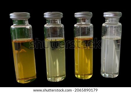 Transformer oil bottles are dark yellow indicating usage at high temperatures for Testing Dissolved Gas Analysis isolated on a black background.no focus