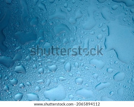 Rain drops on glasses surface with blue background . Natural Pattern of raindrops isolated on blue background.