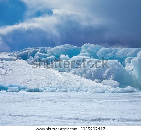 Winter ice landscape under windshtorm clouds. Ice-drifts on siberian lake Baikal. Royalty-Free Stock Photo #2065907417