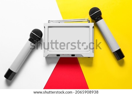 Modern microphones with audio system on color background