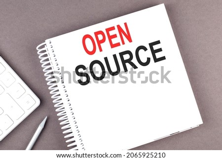 OPEN SOURCE text on notebook with calculator and pen,business