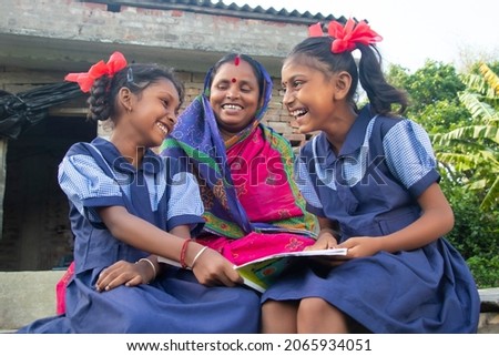 Indian mother helping daughters with homework Royalty-Free Stock Photo #2065934051