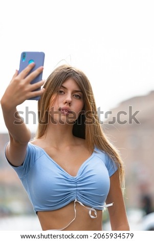 Young woman taking selfies with her smartphone outdoors