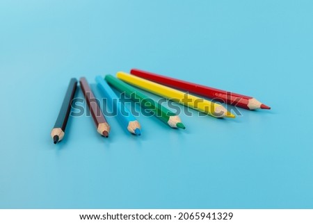 Composition with colored pencils on a bright blue background. top view. space for text.frame