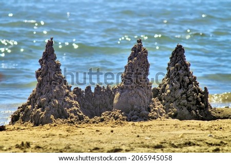 sand creation with three peaks and a blurred sea background