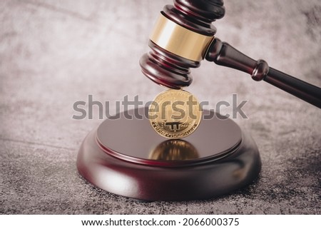 Representative cryptocurrency under the judge's gavel in the foreground.