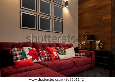 Christmas design cushions on an armchair in a house with a wall with pictures to mount photos