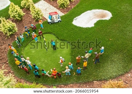 Closeup photo of tiny model people playing golf in England