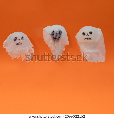 Helloween ghosts hovering with an orange background