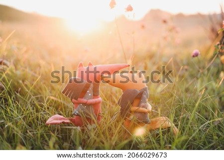 Cute little handmade toy fox in green grass. Childhood, baby, holiday, people, hobby, emotions concepts.