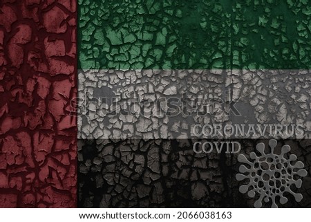 flag of united arab emirates on a old vintage metal rusty cracked wall with text coronavirus, covid, and virus picture.