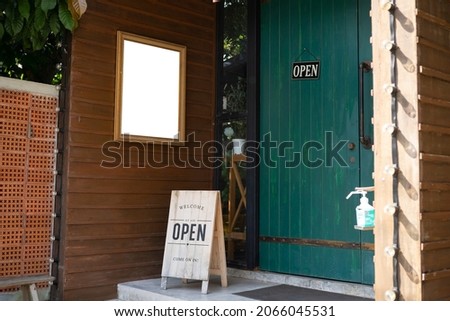 An opening metal sign on the floor in front of the coffee shop. Mockup Frame or Display Poster Template Special Promotion Put In Front of The Wall