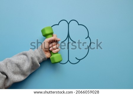 The silhouette of the brain and dumbbells in it. A symbol of exercises for brain development