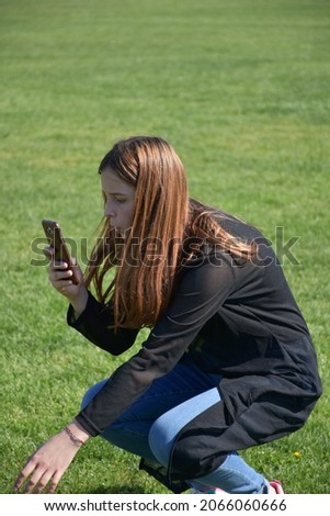 a girl and a phone on a football field,