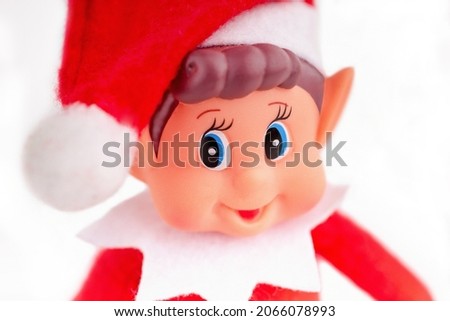 Christmas Elf toy face close up on a  white background. Christmas spirit, Christmas shelf tradition.