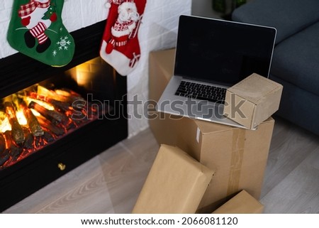 Laptop computer with white blank empty screen on Merry Christmas with presents gifts. Ecommerce website online shopping delivery ads.