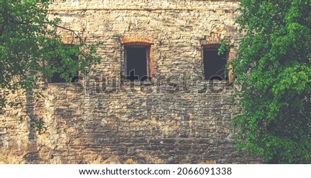 Old brown stone wall. Stone wall texture. Old bricks in old medieval wall. Exterior historical building. Village rural background. Graphic texture element.