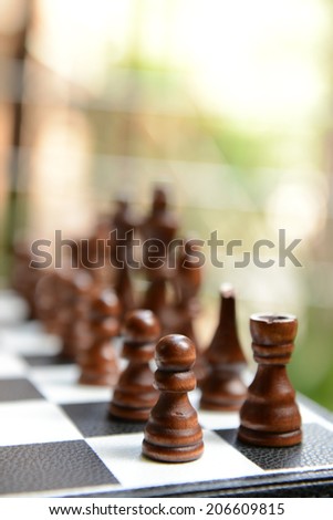 Chess board with chess pieces on light background